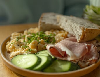 Plate Of Scrambled Eggs Ham and Cucumber Slices at Assisted Living Facility Plate Of Scrambled Eggs Ham and Cucumber Slices at Assisted Living Facility