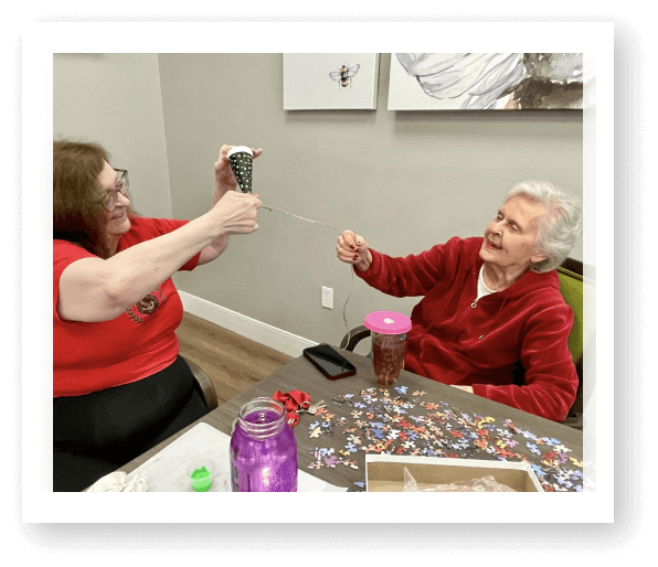 Elderly Women Working on Puzzle Together During Activity at Assisted Living Facility