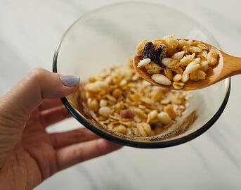 Bowl Of Granola Cereal Held by Hand at Assisted Living Facility Bowl Of Granola Cereal Held by Hand at Assisted Living Facility