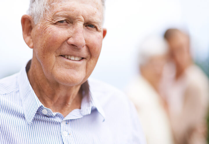 Elderly Man Smiling Outdoors in Striped Shirt at Assisted Living Facility Elderly Man Smiling Outdoors in Striped Shirt at Assisted Living Facility