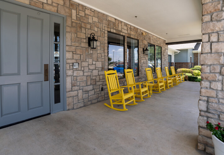 Covered Front Porch with Rocking Chairs for Seniors at Assisted Living Facility