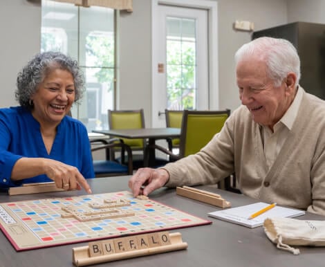 Elderly Couple Playing Scrabble at Table at Assisted Living Facility Elderly Couple Playing Scrabble at Table at Assisted Living Facility