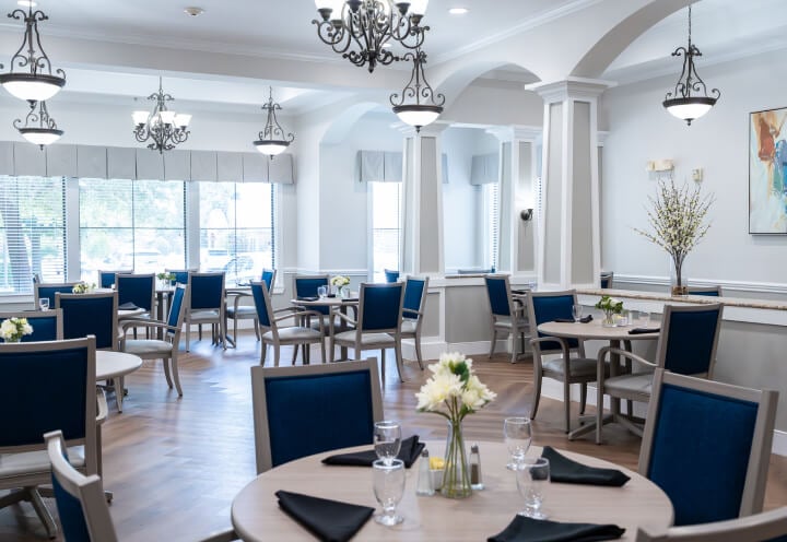 Dining Room with Round Tables Set for Seniors at Assisted Living Facility Dining Room with Round Tables Set for Seniors at Assisted Living Facility