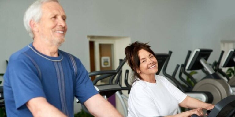 Group of Elderly Lifting Dumbbells Outdoors at Assisted Living Facility